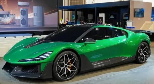 亮绿色高性能跑车在展厅内，线条流畅，前脸低趴，配有黑色碳纤维前唇和LED日行灯