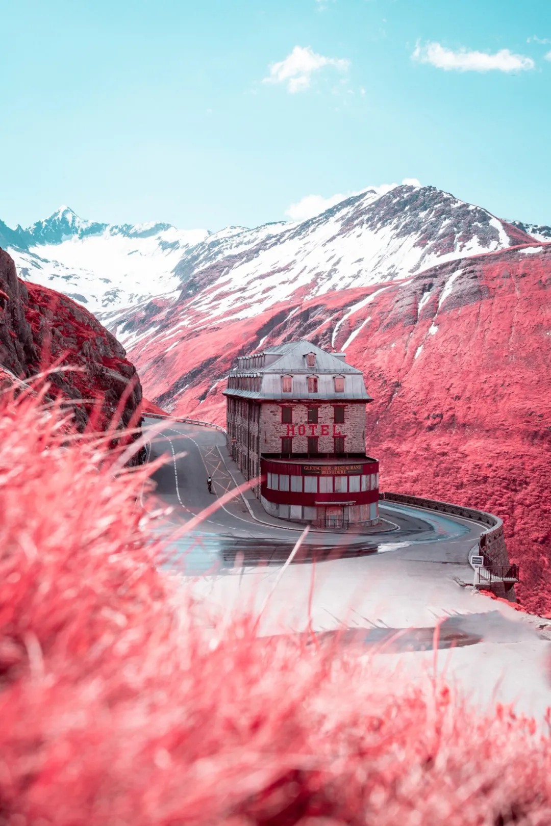 红外滤镜下的红白酒店建筑与粉红色山坡