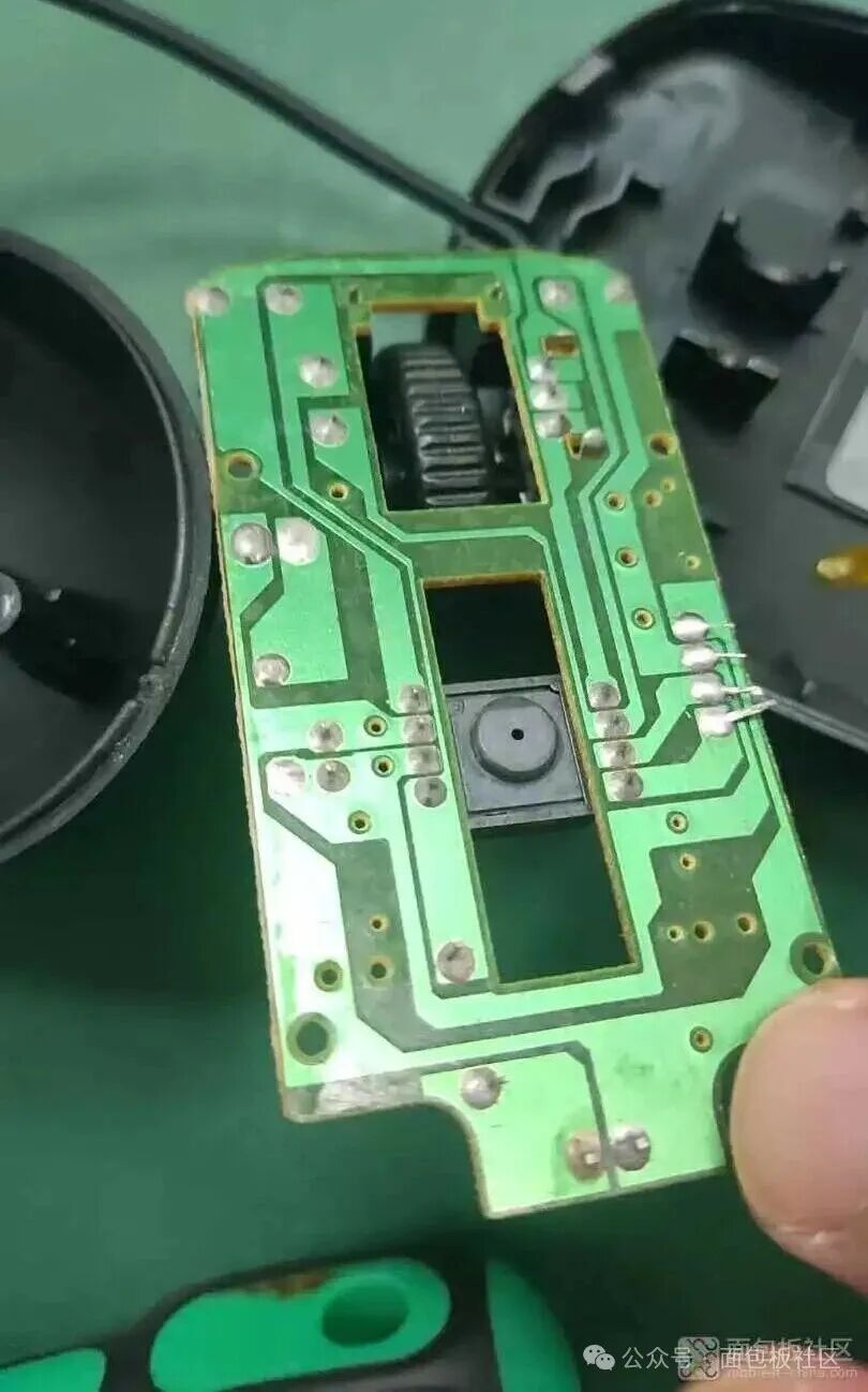鼠标PCB背面视图，展示光学传感器开口