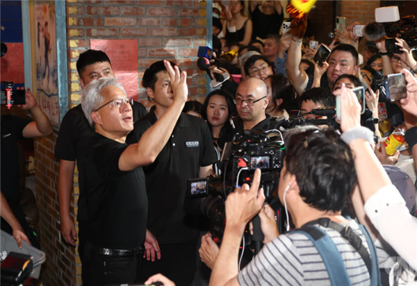黄仁勋在人群中央双手比出赞许手势