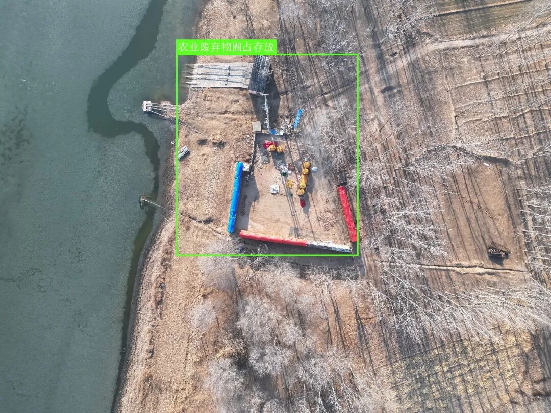 一张荒地航拍图，模型准确检测出一处农业废弃物存放区域