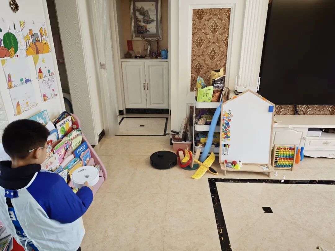 儿童与扫地机器人共处的家庭场景