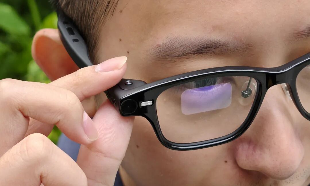 男子佩戴并调整智能眼镜上的摄像头模块