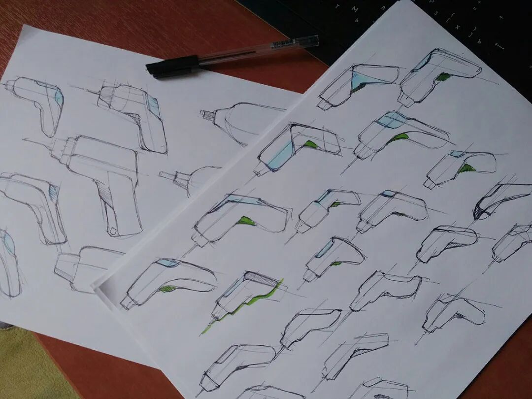 两张白纸上布满了手绘的电动工具设计草图，主要为电钻或螺丝刀的造型