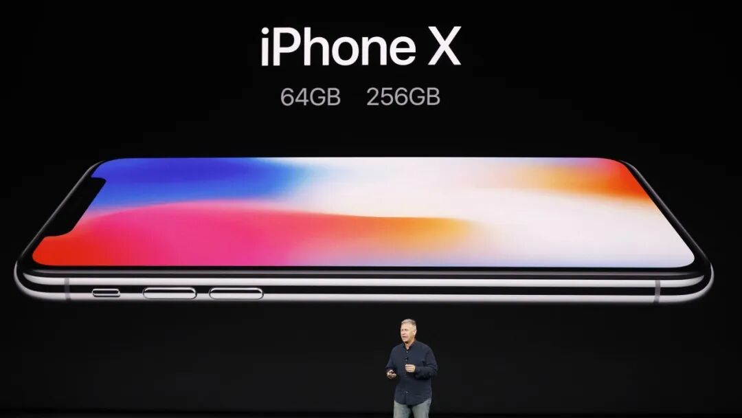 iPhone X发布会现场，屏幕显示彩色渐变壁纸