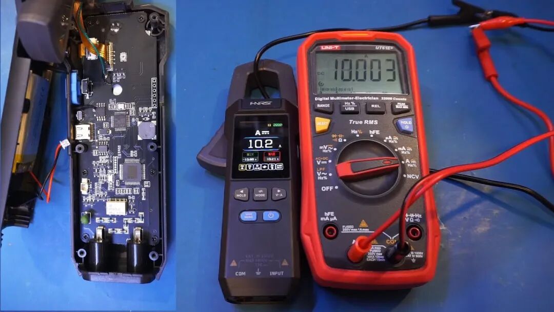 FNIRSI DMC-100 直流 10A 档实测同框对比:读 10.2A,UT61E+ 读 10.003A,左侧为拆解主板