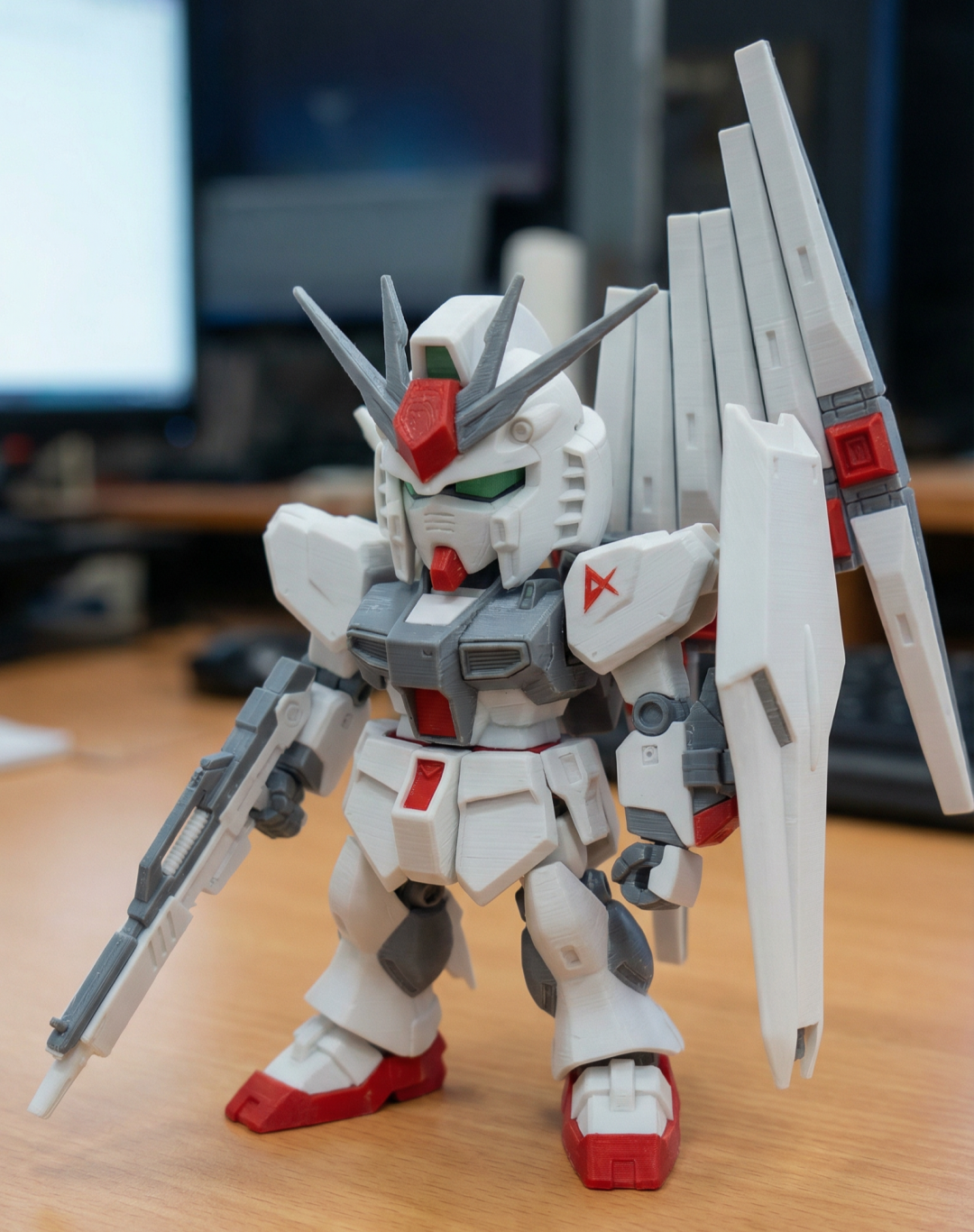 一个摆放在桌面上的红白高达实体模型照片