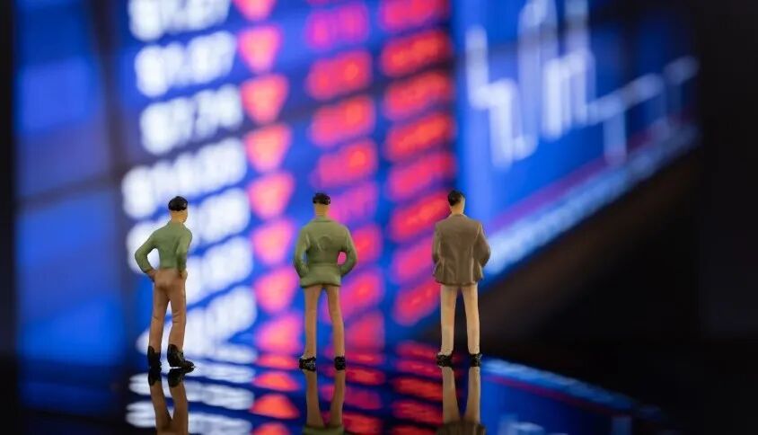 微型模型人物站在股票行情显示屏前