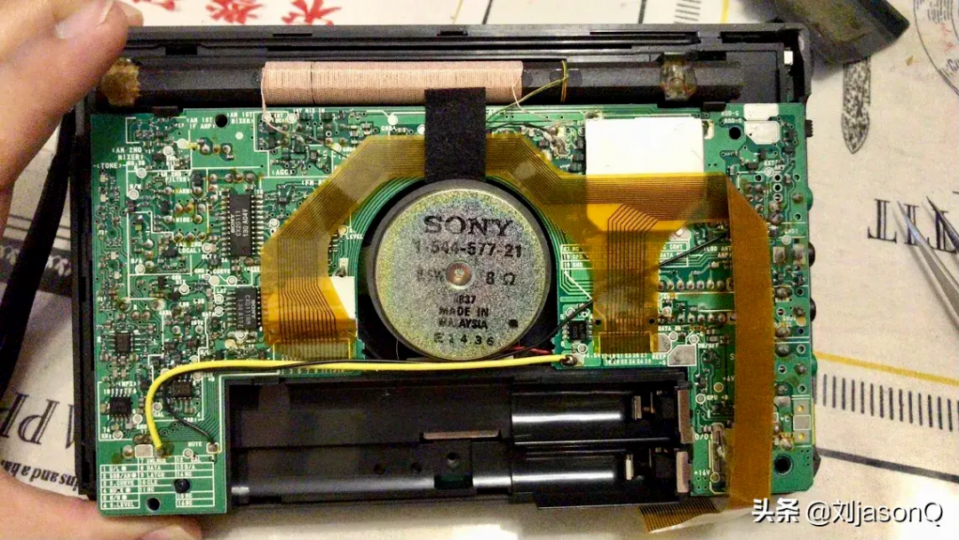 拆开后盖的设备，内部为索尼扬声器及绿色电路板