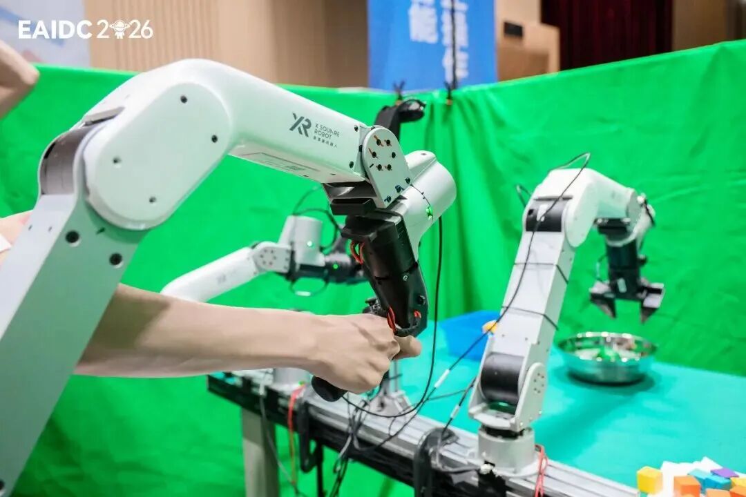 EAIDC 2026比赛现场，技术人员正在调试一台白色XR机械臂