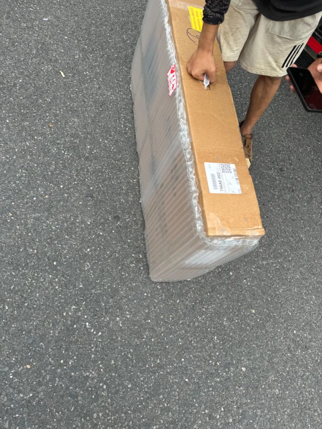 开箱过程：用刀划开包裹气泡膜的纸箱