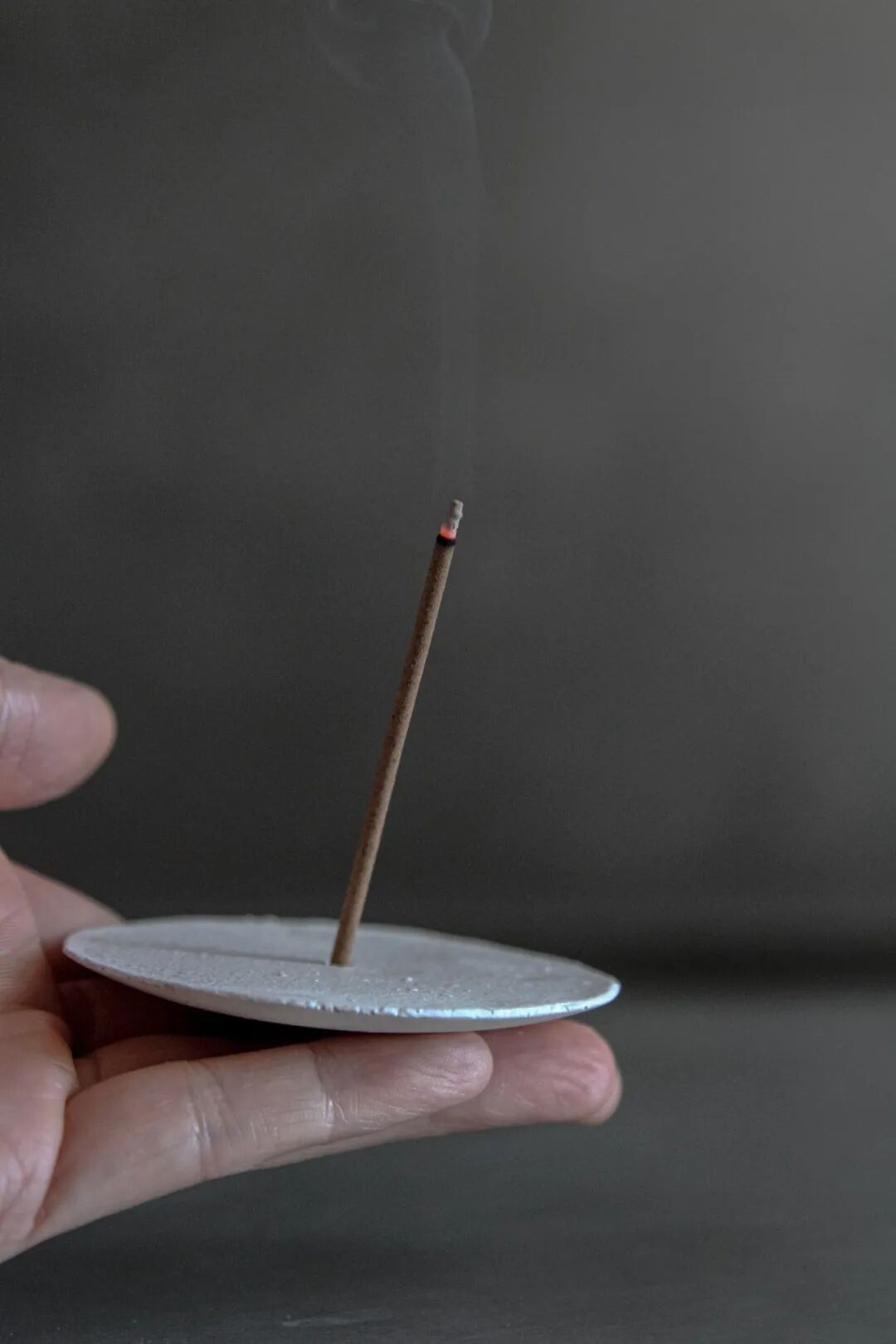 手持燃烧线香的特写