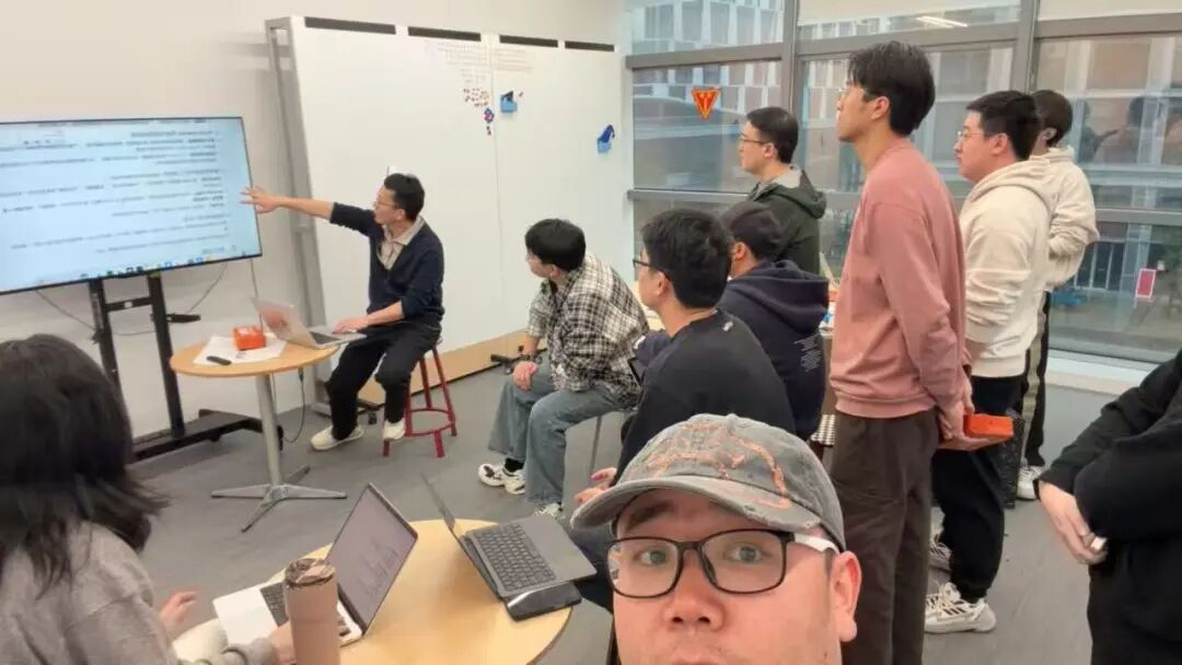 NoDesk AI创始人宋健正在向团队讲解，背景是技术内容大屏