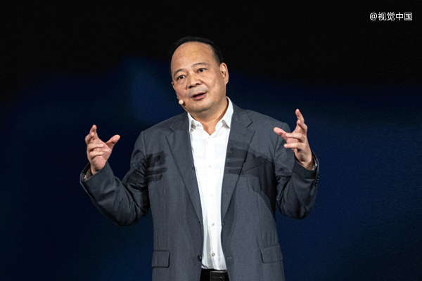 一位中年男性在深蓝色背景前进行正式演讲