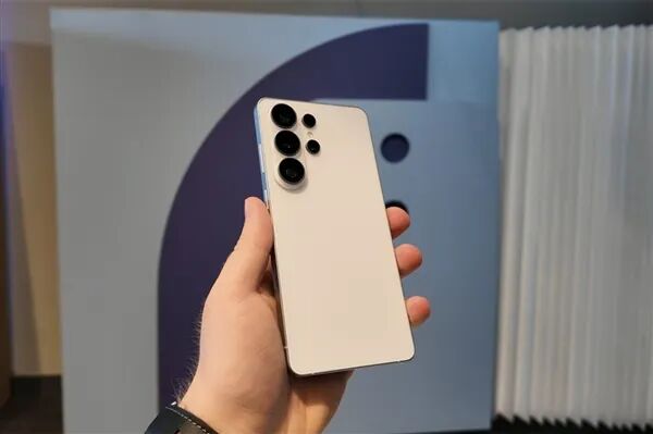 手拿白色三星手机，背景为蓝白几何图案