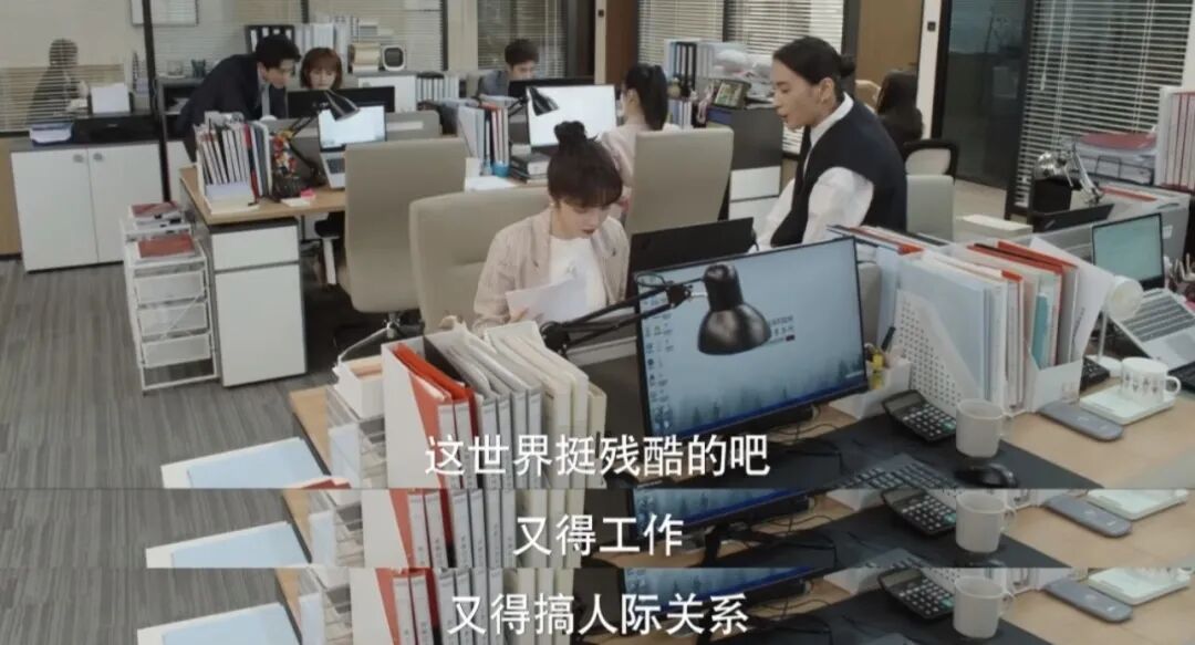 办公室场景，字幕“这世界挺残酷的吧，又得工作，又得搞人际关系”
