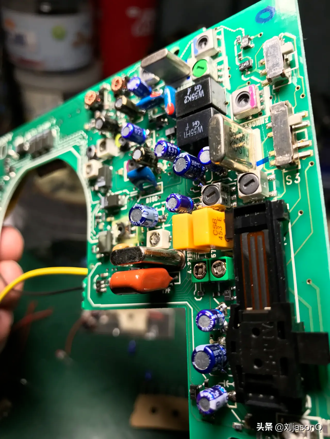 绿色PCB特写，包含贴片三极管、钽电容及电感等元件