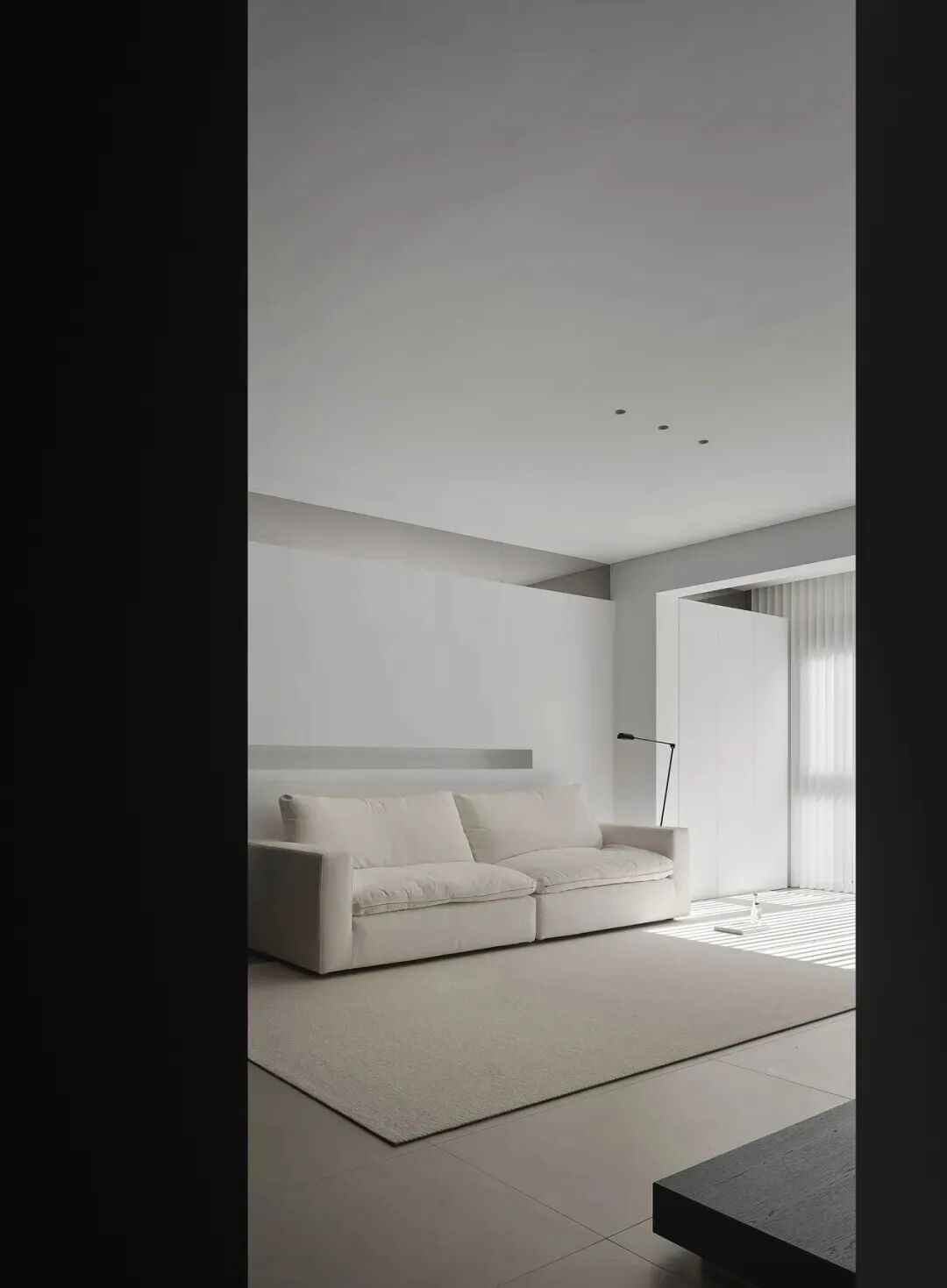 极简客厅，白色沙发与百叶窗光影