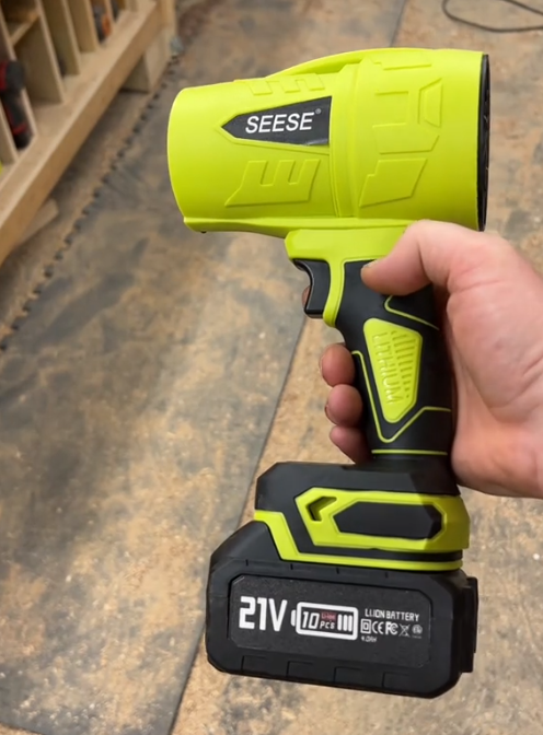 手持SEESE亮绿色电动工具的特写图