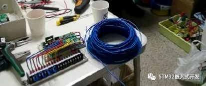 嵌入式工程师的工作台，摆满电路板、传感器和开发工具