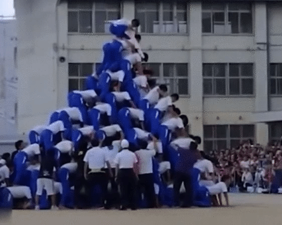 一群人搭建人塔，象征紧密依赖