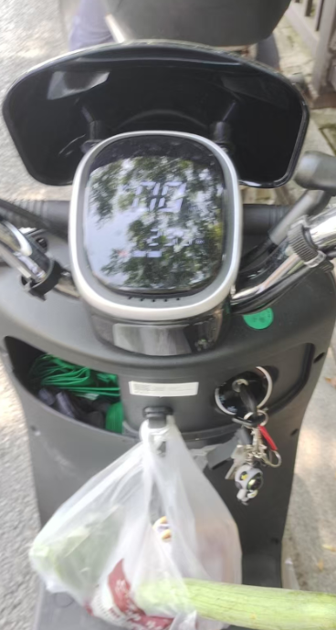 黑色电动车前部特写，车把挂有钥匙