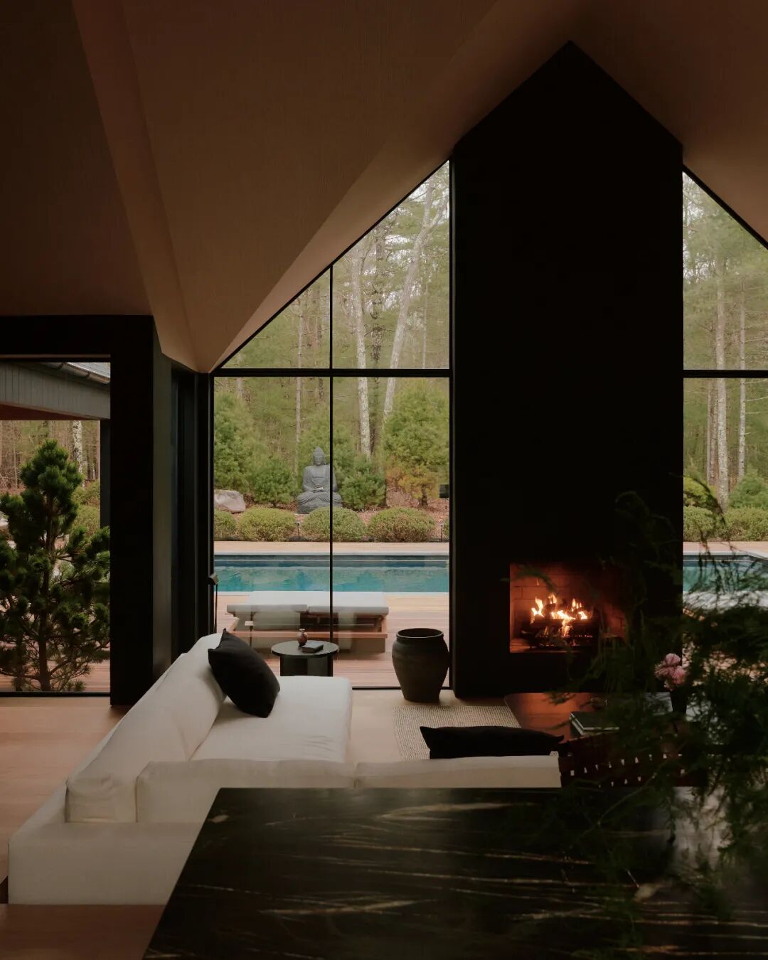 室内客厅，壁炉与室外泳池景观相连