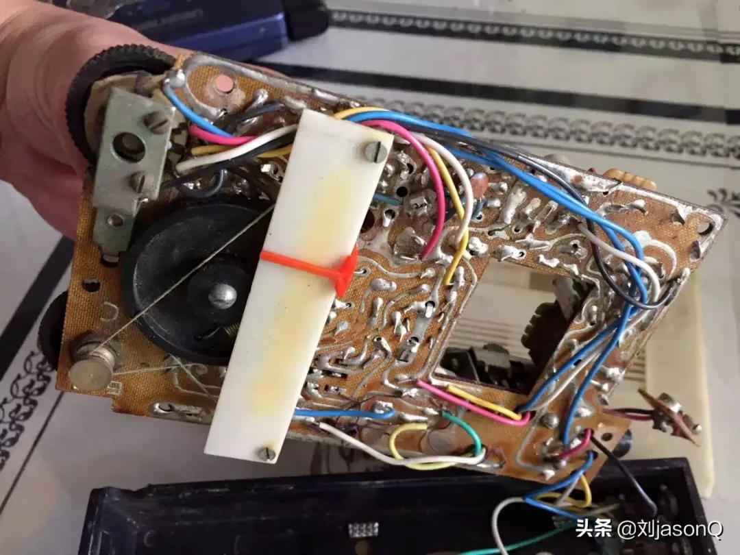 手持老旧电路板，布满元件与彩色连接线