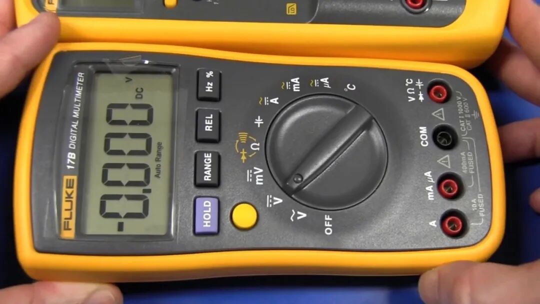 Fluke 17B 面板与转盘特写,HOLD、MIN MAX、RANGE、REL 四个功能按键,转盘外圈印有各档位符号,右侧为插孔区