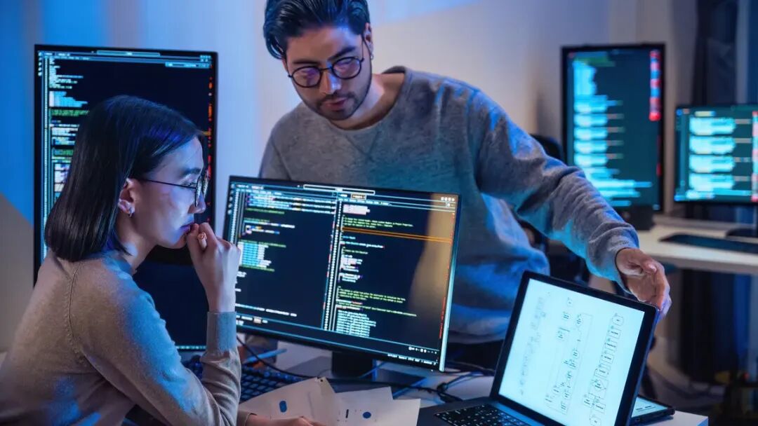 两名程序员在工作室中讨论代码