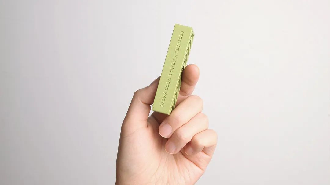 手握浅绿色长方体再生材料积木特写