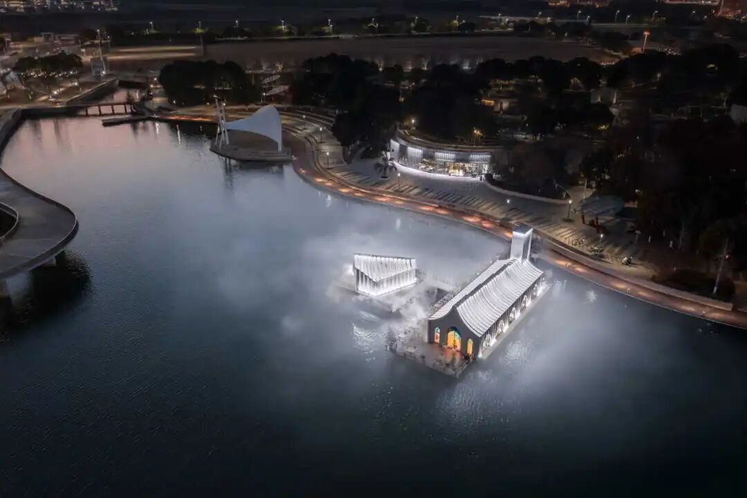 天鹅湖建筑群夜景航拍，水面雾气弥漫