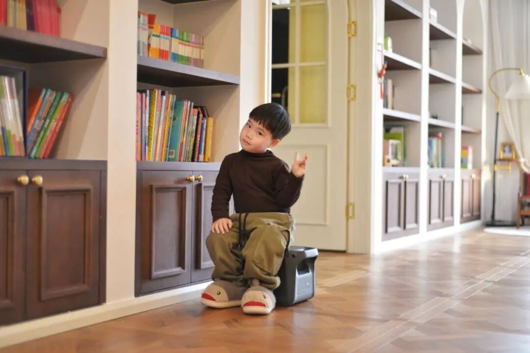 孩子坐在电源上比耶手势