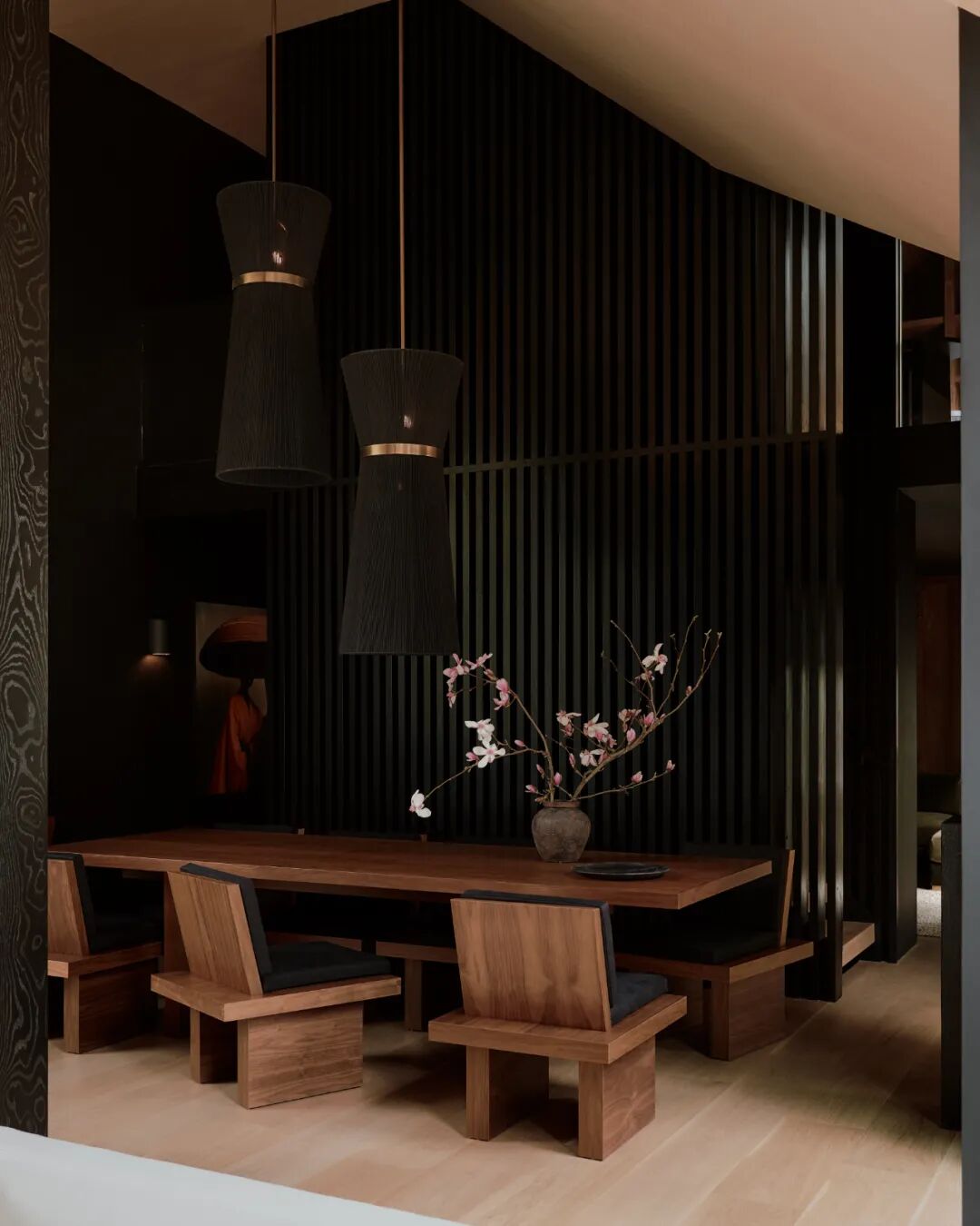 深色背景墙前的原木色餐桌区