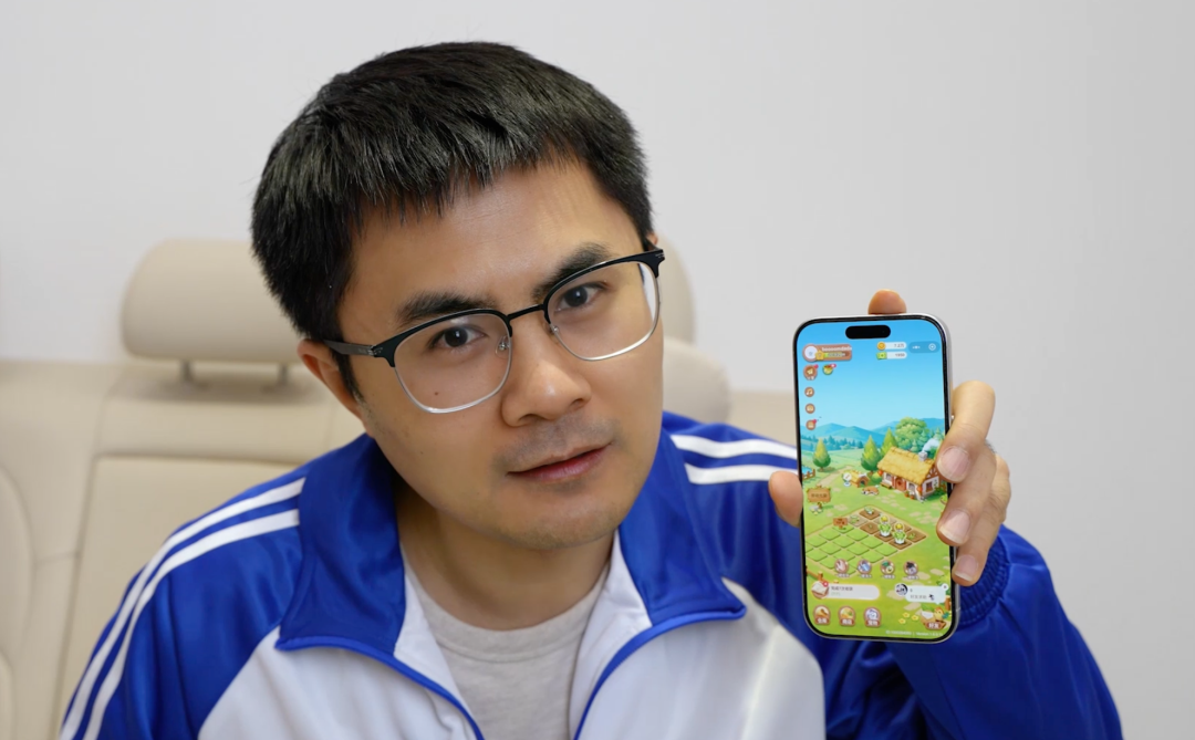 手持手机玩复古农场游戏的男子