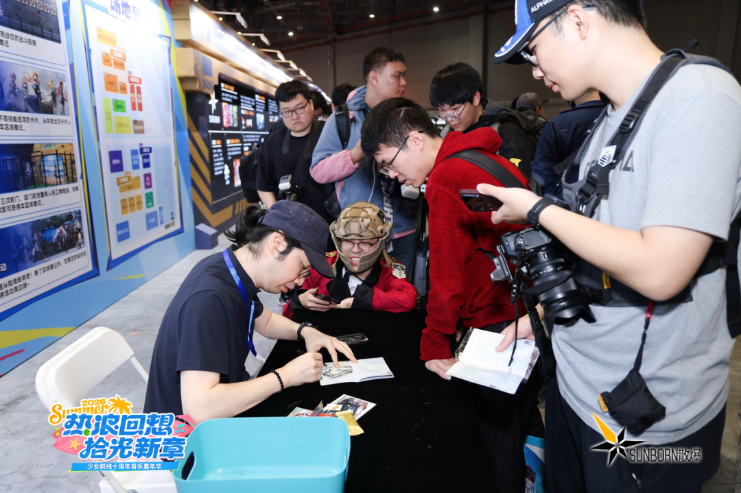 少女前线十周年音乐嘉年华现场，大量指挥官在展台前排队互动、签名留念，背景是2023 Summer主题展板
