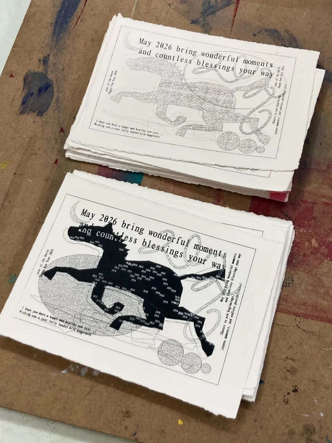 印刷品堆叠：马形剪影由密集文字构成，祝福语“May 2026 bring wonderful moments...”