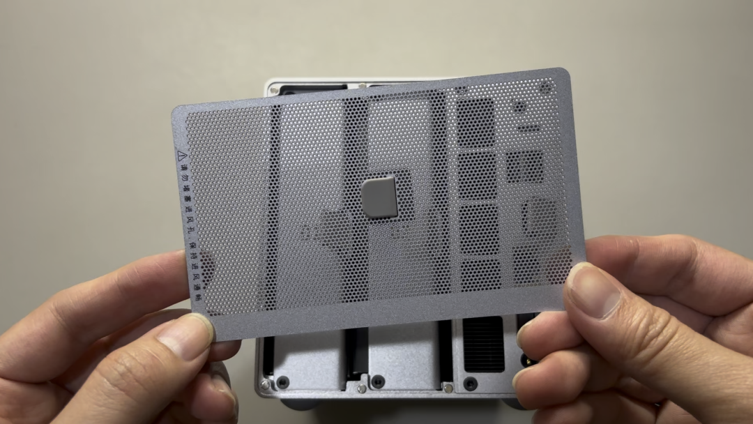 手拿设备后盖，上有散热孔