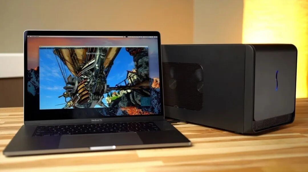 一台MacBook Pro笔记本电脑正在进行性能测试,旁边连接着黑色外设