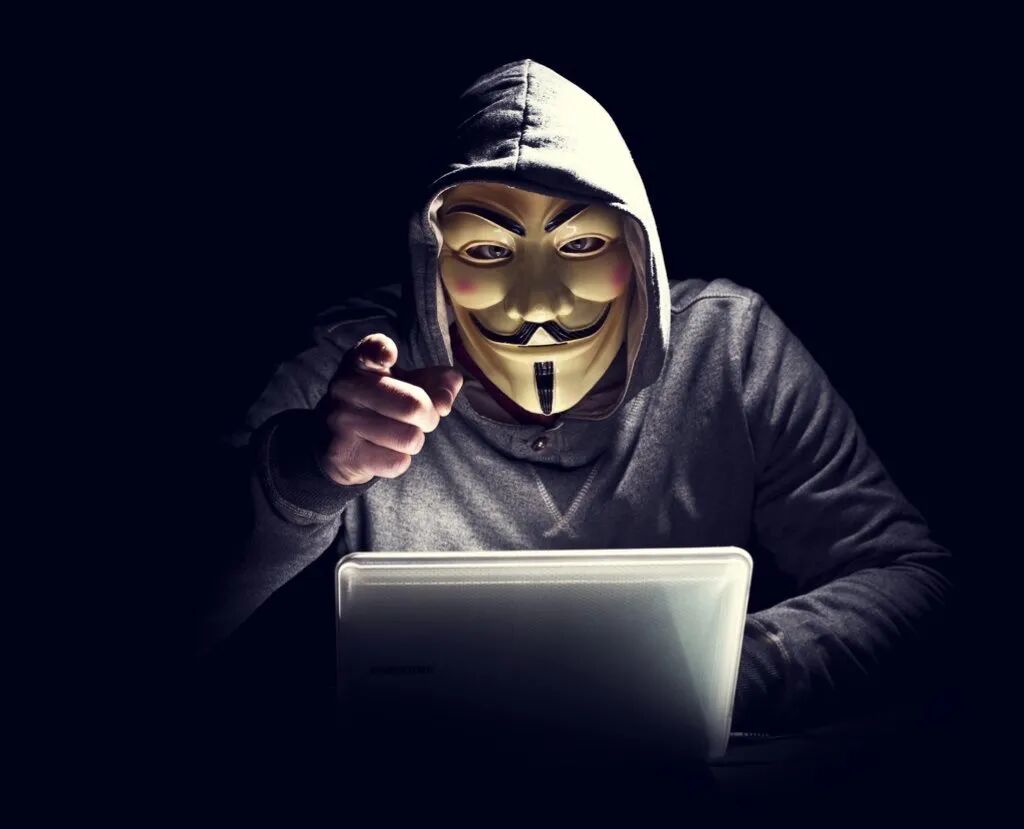 戴着面具的黑客在黑暗中操作电脑