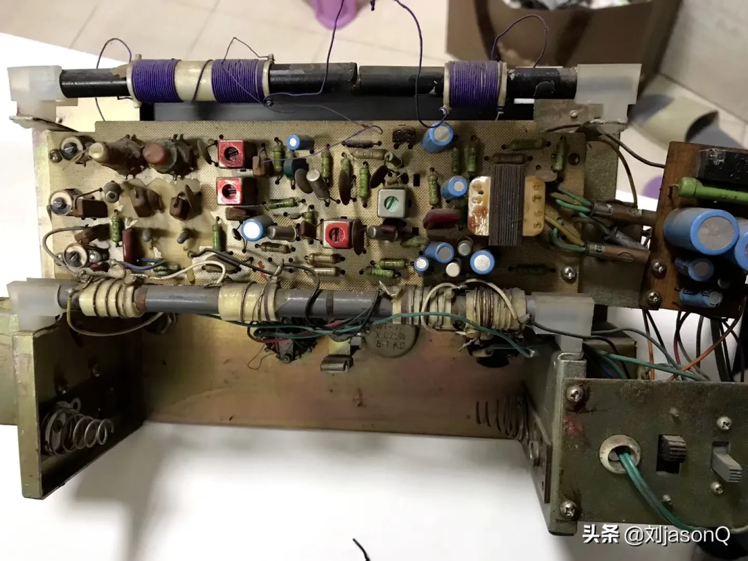 老式收音机或放大器内部，含电位器、线圈及杂乱布线