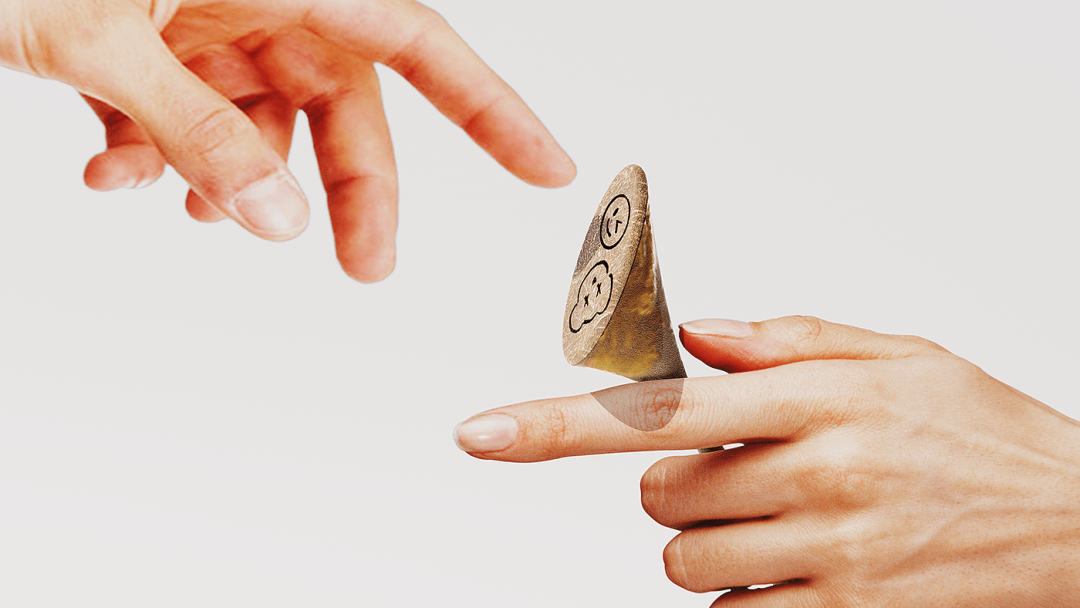 手部与带有笑脸图案的锥形物体互动