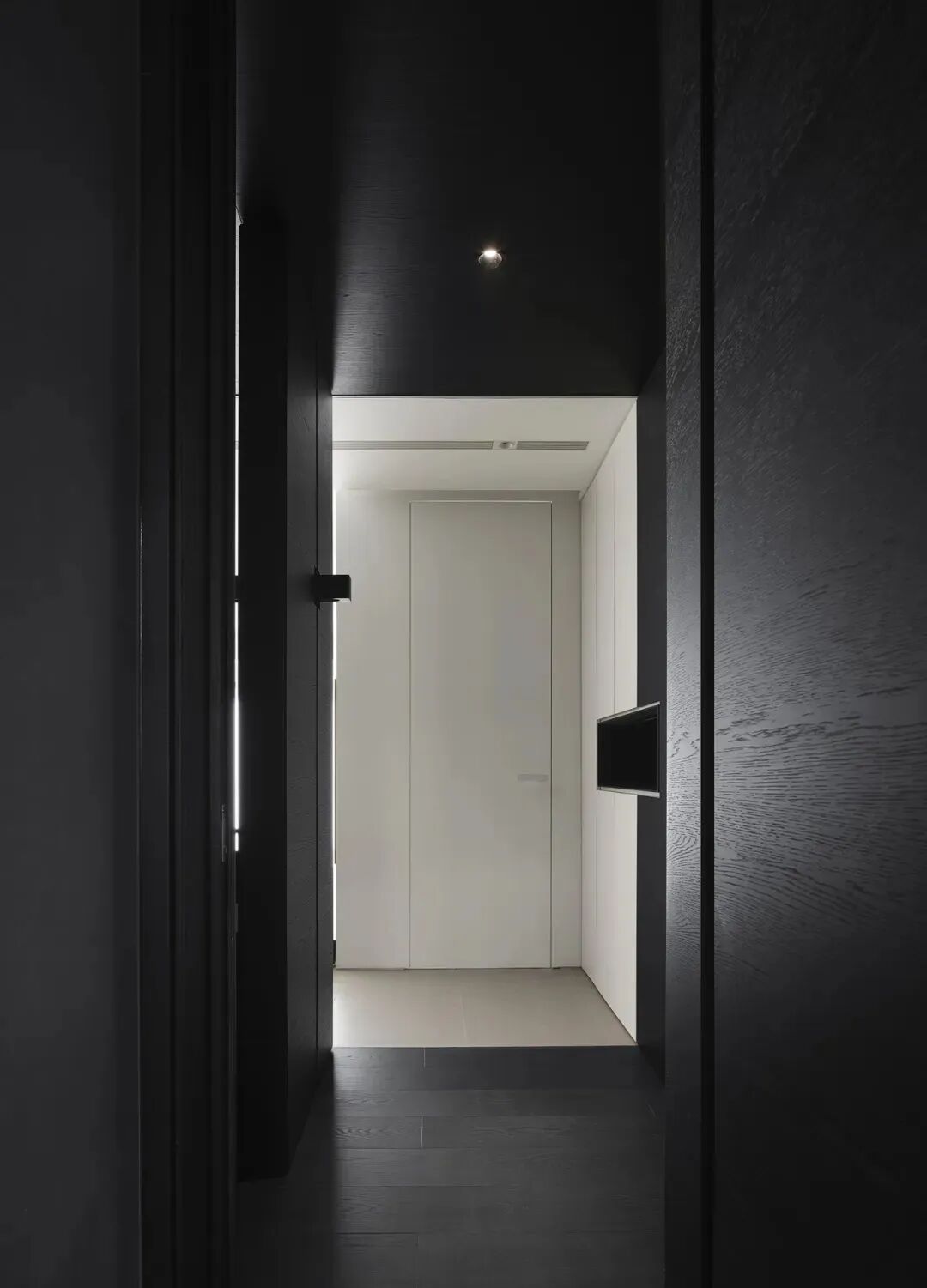 黑色走廊望向白色房门