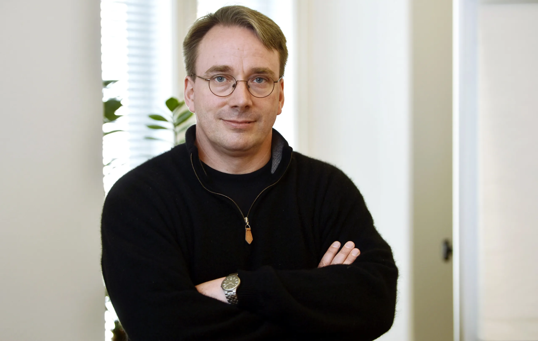 Linus Torvalds 面带微笑，双臂交叉站立
