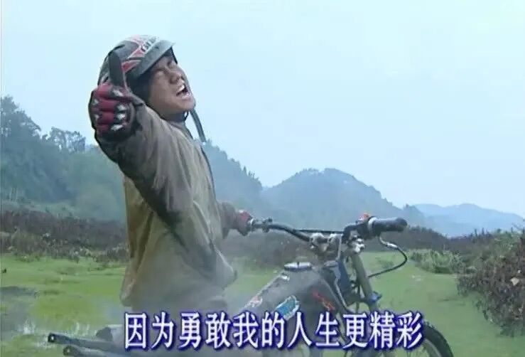 张雪在泥地中骑行并竖大拇指大笑