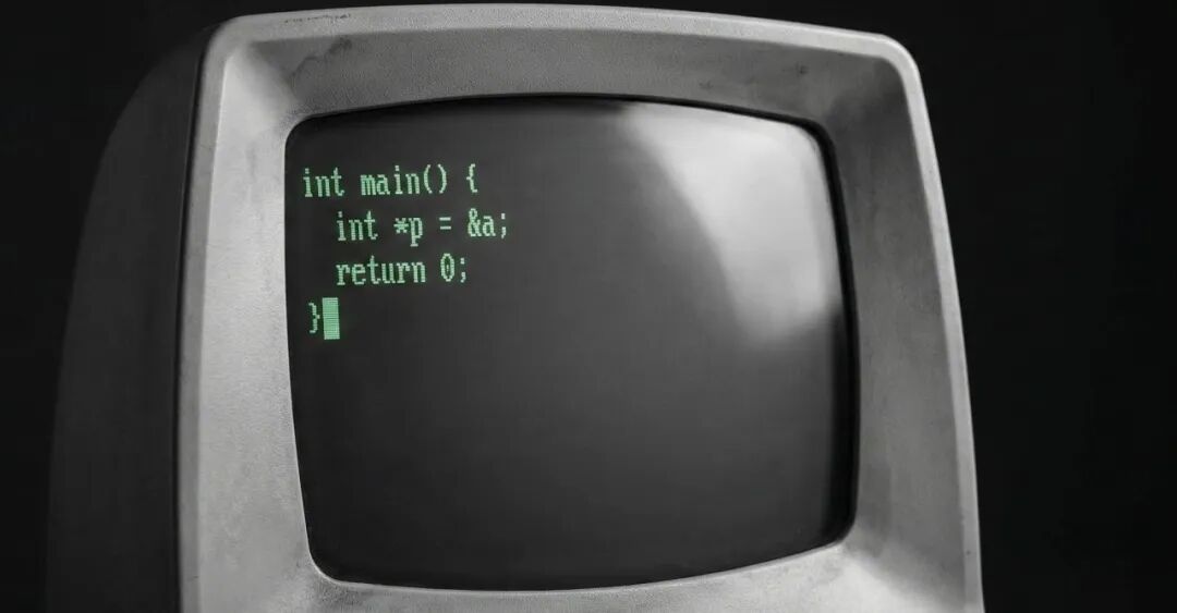 一台复古电脑显示器屏幕上显示着C语言指针代码
