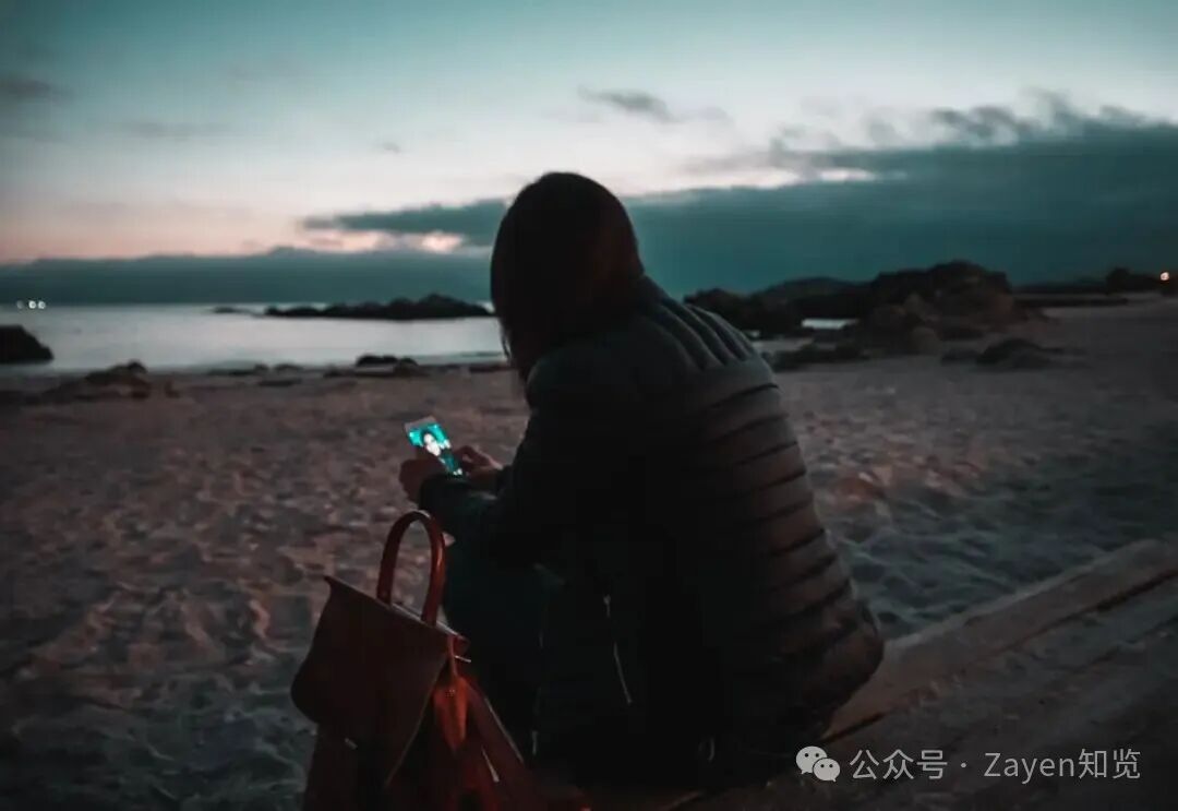 黄昏海边使用手机剪影