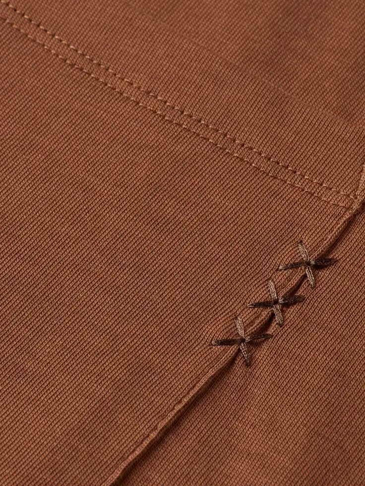 棕色斜纹编织面料特写，右下角可见对角线排列的深色十字形缝线装饰