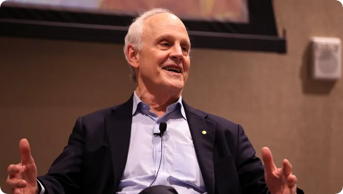 诺贝尔物理学奖得主 David Gross 微笑演讲,身前佩戴领夹麦克风