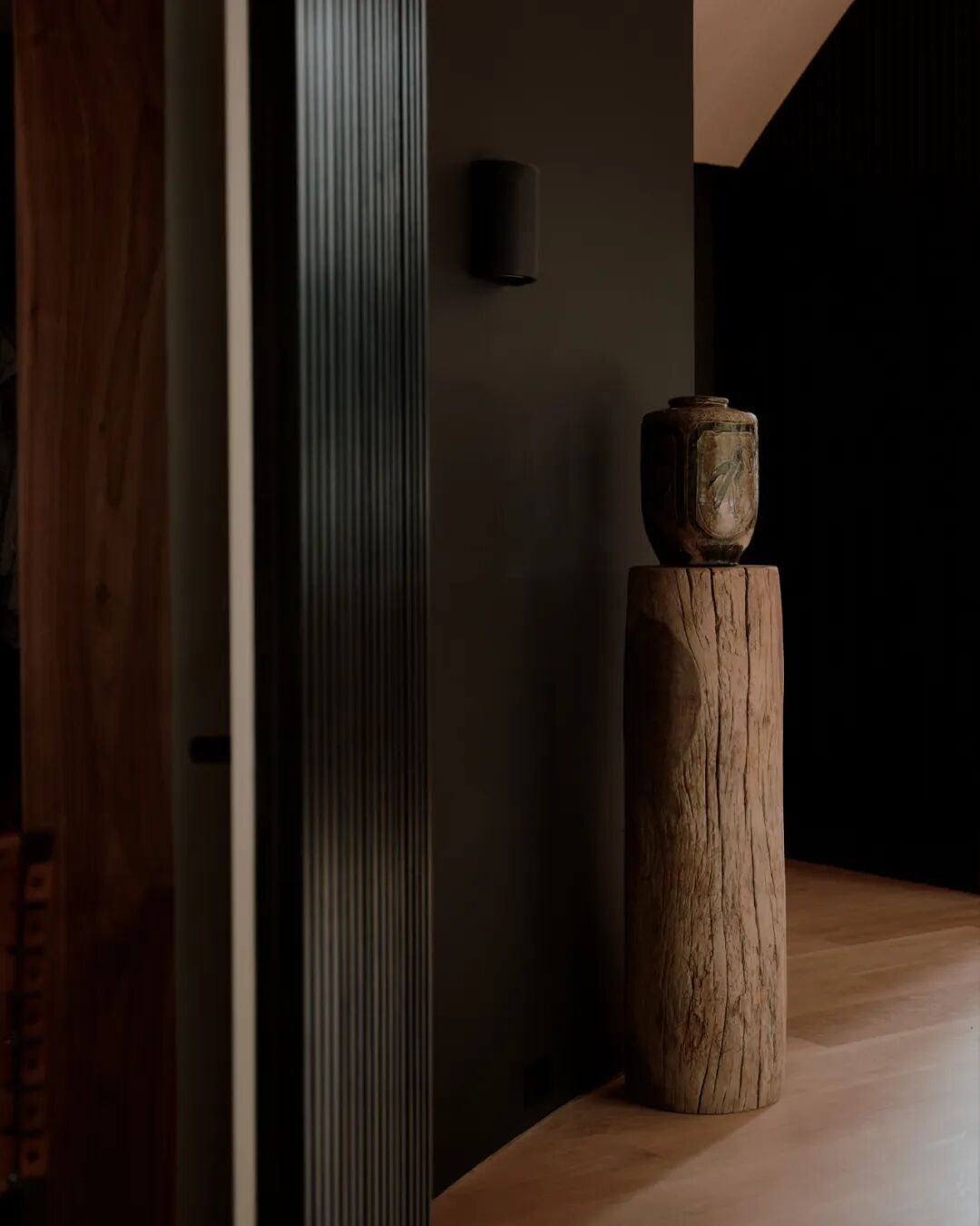 原木桩上的古朴陶罐与壁灯